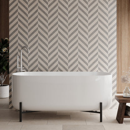 A freestanding white acrylic bath with an elevated stand, positioned in a bathroom with patterned wall tiles.