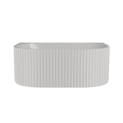 An oval white acrylic bathtub with fluted sides, back wall mounted, with a central waste position.