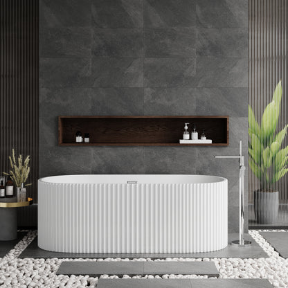 A freestanding white oval bathtub with a fluted design, situated in a bathroom with dark gray walls and a central shelf above the tub featuring toiletries.