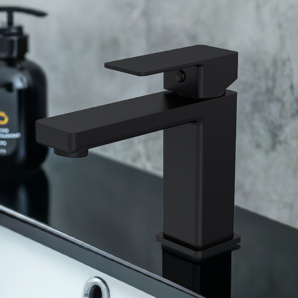 A matt black mono basin mixer featuring a bold, angular design. On a black gloss vanity with white basin and chrome overflow.